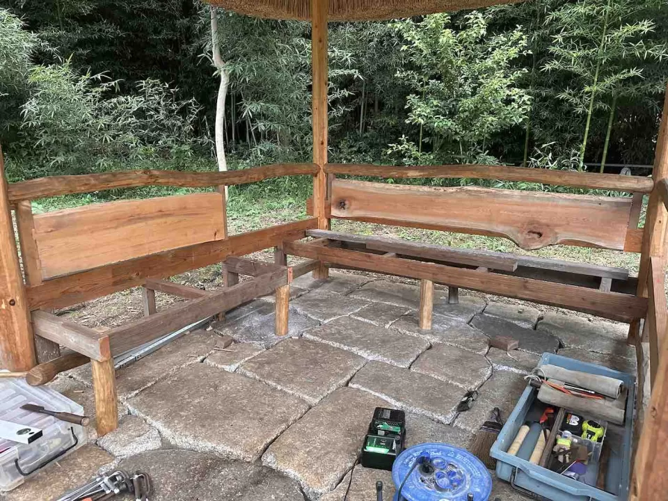 茅ヶ崎市の茅葺きの四阿施工中の様子で、腰掛を施工している途中風景