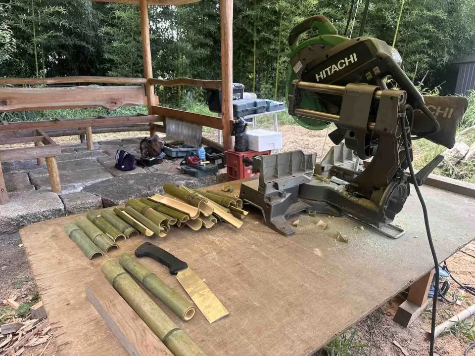 茅ヶ崎市の茅葺きの四阿施工の一幕、座面下の腰壁に割竹を貼る準備風景