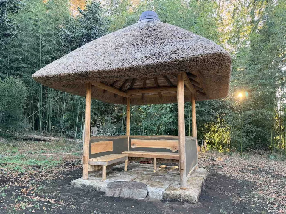 竹林に囲まれ、西日を背に佇む茅ヶ崎市の茅葺きの四阿〝茅石亭〟