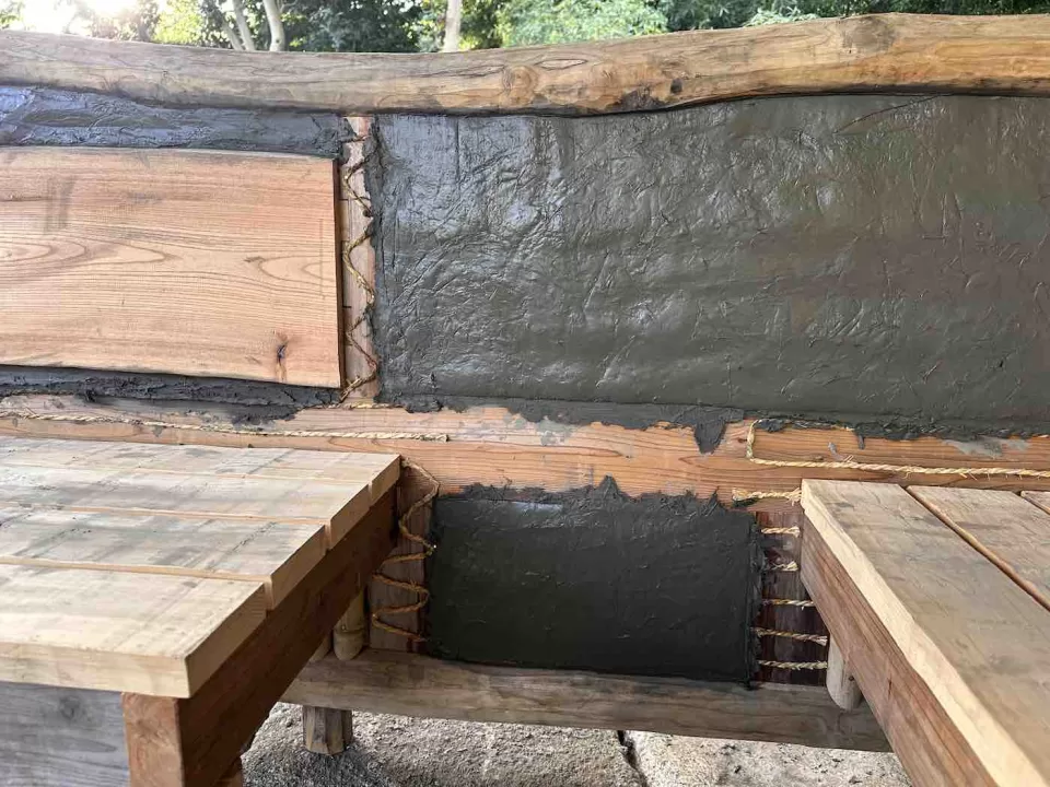 茅ヶ崎市の茅葺きの四阿施工中の風景で、通貫を避けて荒壁土を塗り終わった様子