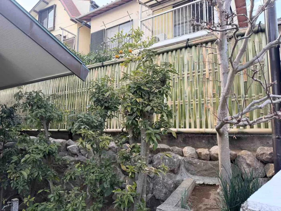 湯河原吉浜の大津垣作成工事の完成風景で、母屋の玄関横から胴縁四段の大津垣を眺めた様子